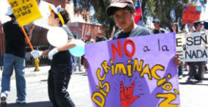 Boy holding no discrimination sign.